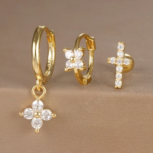 Close-up of gold plated 925 silver earring set with zircons and floral cross charms