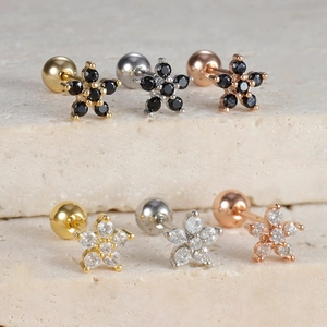 Macro detail of stainless steel flower cartilage studs with screw ball backs in various colors