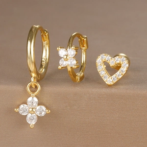 Detailed macro shot of 925 silver gold-plated earring set with zircon flower and heart charms