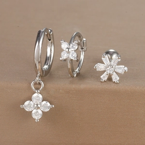 Detailed view of silver flower and snowflake earrings set with cubic zirconia stones