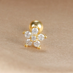 Macro shot of gold flower cartilage stud with clear zircons and screw ball back