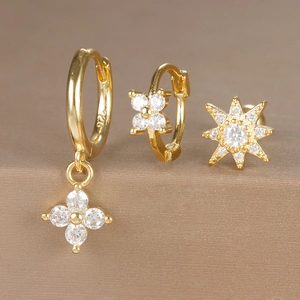 Detailed macro view of S925 gold plated silver earring set with zircons and flower charms