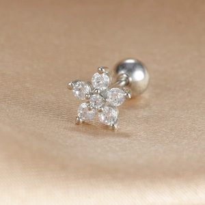 Macro detail of silver flower screw back earring with sparkling zircon stones