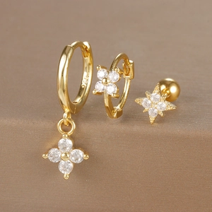 Macro detail of gold floral earrings set with white zircons and S925 hallmark
