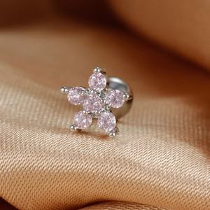 Macro view of flower cartilage stud with pink zircon petals and silver screw ball back