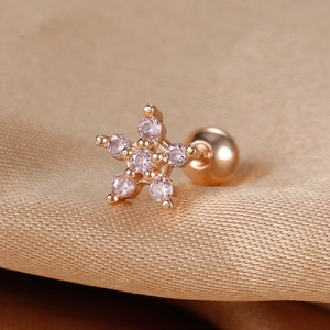 Macro shot of rose gold star stud earring with pink zircon stones and screw back ball