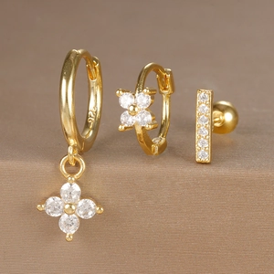 Macro detail of gold plated 925 silver hoop earrings set with zircon flower charms