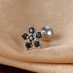 Macro shot of stainless steel star piercing stud with black cubic zirconia and screw back