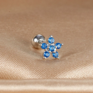 Detailed close-up of a silver star ear stud with six vibrant blue cubic zirconia stones