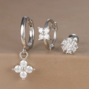 Macro detail of silver floral earring set with sparkling cubic zirconia on brown surface