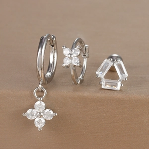 Detail shot of three-piece silver earrings set with micro-pave zircons and floral motifs