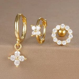 Macro view of gold hoop earrings set featuring zircon floral charms and 925 silver hallmark