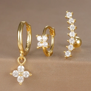 Macro shot of three gold S925 silver hoop earrings with zircon flowers and crystal detail