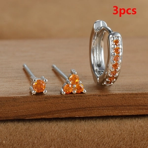 Detalle del conjunto de 3 pendientes plateados con brillantes circonitas de color ámbar