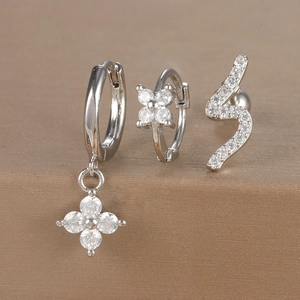 Detailed close-up of a silver-toned earring set featuring zircon flowers and S-shaped designs