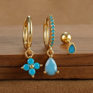 Detail of 925 sterling silver turquoise earring set with gold plating and flower charms