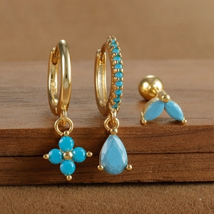 Close-up of S925 sterling silver turquoise flower and drop earrings on wooden base