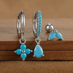 Detailed macro of S925 silver earring set with turquoise stones and floral motifs