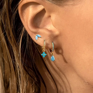 Bohemian gold turquoise earring set featuring floral studs and drop hoop earrings on model