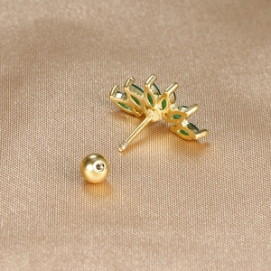 Macro shot of gold stainless steel tragus stud with green marquise zircon crown