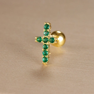 Macro view of gold cross stud earring with green zircon insets and screw-back closure