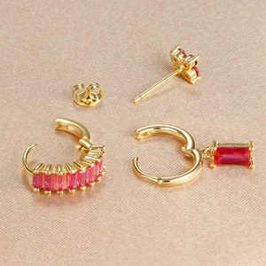 Vue macro de boucles d'oreilles en pierres précieuses rouge rose sur fond de soie