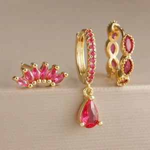 Détail de boucles d'oreilles dorées avec pierres de rubis marquise et en forme de goutte