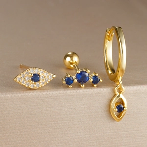 Conjunto de tres pendientes dorados de ojo turco con cristales azules y circonitas