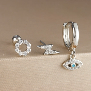 Primer plano de set de pendientes de ojo turco plateados con circonitas y piedra azul