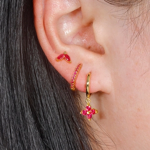 Driedelige vergulde oorbellen set met roze kristallen close-up op het model oor