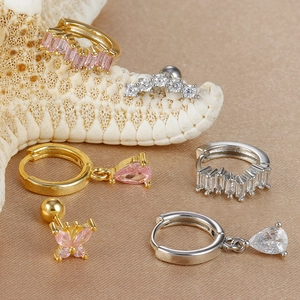 Detail von Gold- und Silber-Creolen mit rosa Schmetterlings- und birnenförmigen Zirkonia