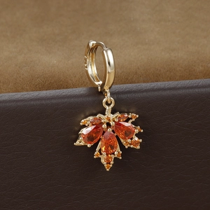 Makroaufnahme der S925 Silber Ahornohrringe mit orangen Zirkonia auf Leder