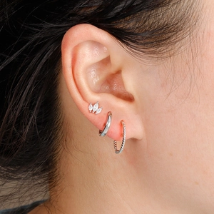 Three-piece silver earring set featuring twisted hoop, plain hoop, and zircon leaf stud