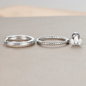 Detailed macro view of S925 sterling silver twist hoops and marquise zircon ear studs