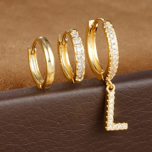 Macro-opname van S925 sterling zilveren gouden oorbellen met zirkoon en L-vormige hanger