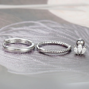 Macro shot of silver S925 huggie hoops with twist texture and crown zircon stud set