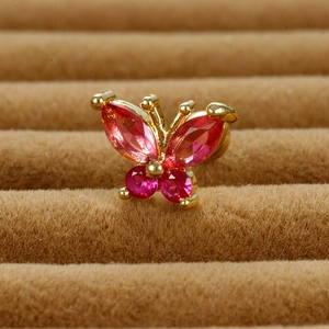 Elegant gold butterfly stud earrings with pink crystal gemstones on brown velvet background