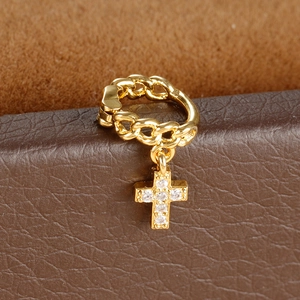 Detail of golden cross drop earring with chain texture and sparkling zircon inlay