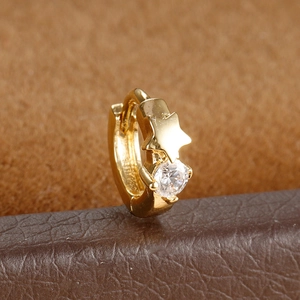 Detail shot of gold huggie hoop earring with star element and sparkling cubic zirconia