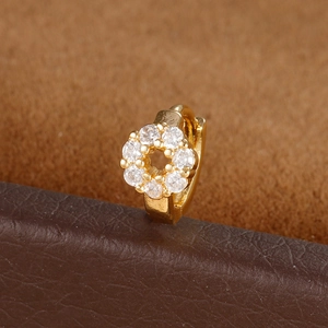 Macro shot of gold floral tragus hoop earring with cubic zirconia on a brown leather stand