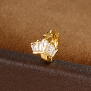 Detail of gold crown ear cuff featuring rectangular zircons and a small cross relief