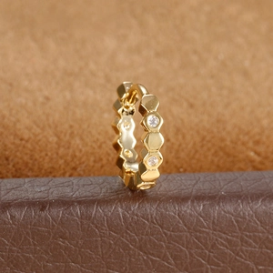 Macro shot of gold hexagonal honeycomb ear cuff with zircon inlay on leather