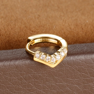 Macro shot of gold V-shaped huggie earring with shimmering micro-set zircons details