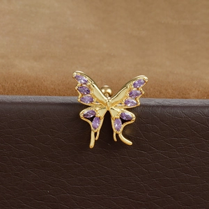 Macro detail of golden butterfly helix stud with purple marquise zircon inlay