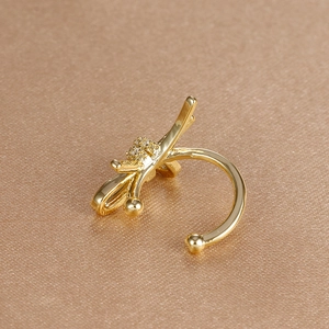 Nahaufnahme der goldenen Ohrklemme mit Zirkonia-Besatz und polierten Kugelenden