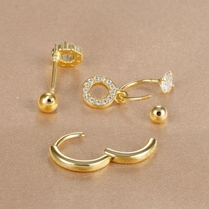 Dettaglio del set di orecchini in argento S925 dorato con zirconi su tessuto di seta