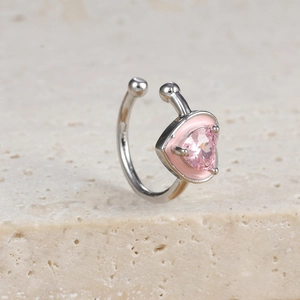 Makroaufnahme des rosa herzförmigen Zirkon-Ohrclips mit Silbermetall und Emaille-Finish