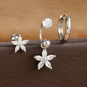 Dettaglio di orecchini a fiore in argento con zirconi su un supporto in pelle scura