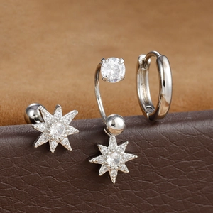 Dettaglio macro di tre orecchini argento con perni a stella in zircone e piccolo cerchio