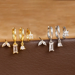 Detailed macro view of gold and silver flower earrings set with sparkling zircon stones